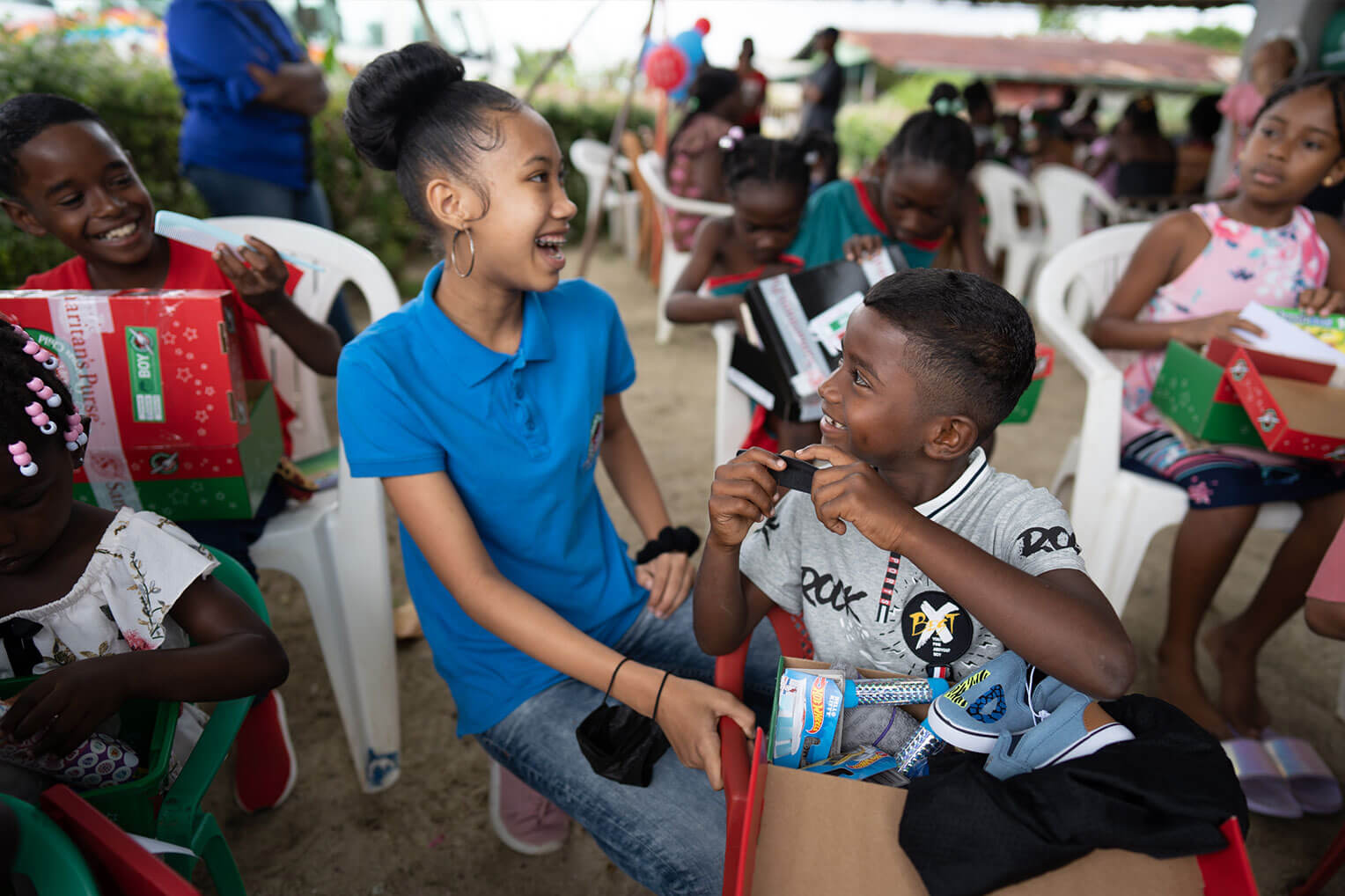 Charahja celebrates opening shoeboxes with young children.