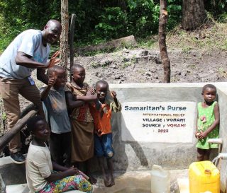 Children enjoy the first cans full of water from their village's protected water point.