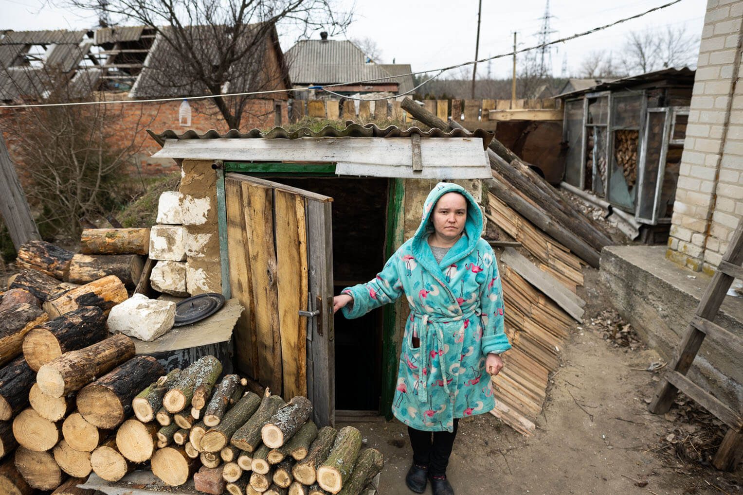 Darya stands outside the cellar where her family takes shelter during shelling.