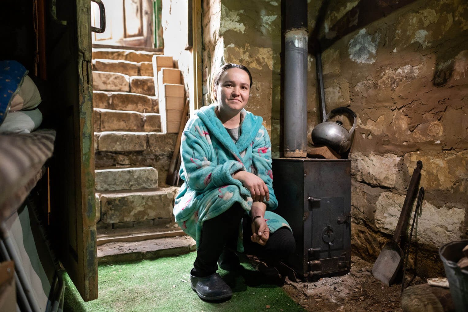 Darya inside her cellar with her new Samaritan's Purse wood-burning stove.
