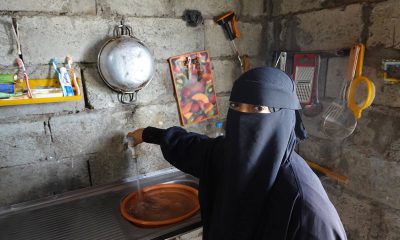 Yemeni woman pours water in her home.