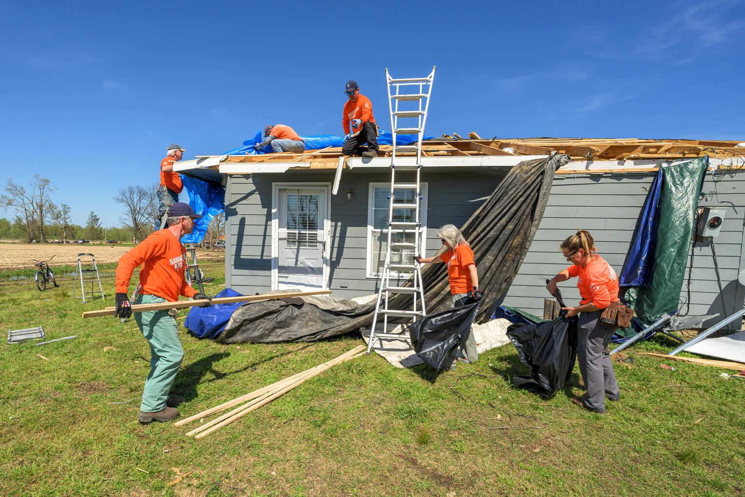 Volunteers are hard at work in Mississippi tarping damaged roofs and clear trees and debris from homes and properties.