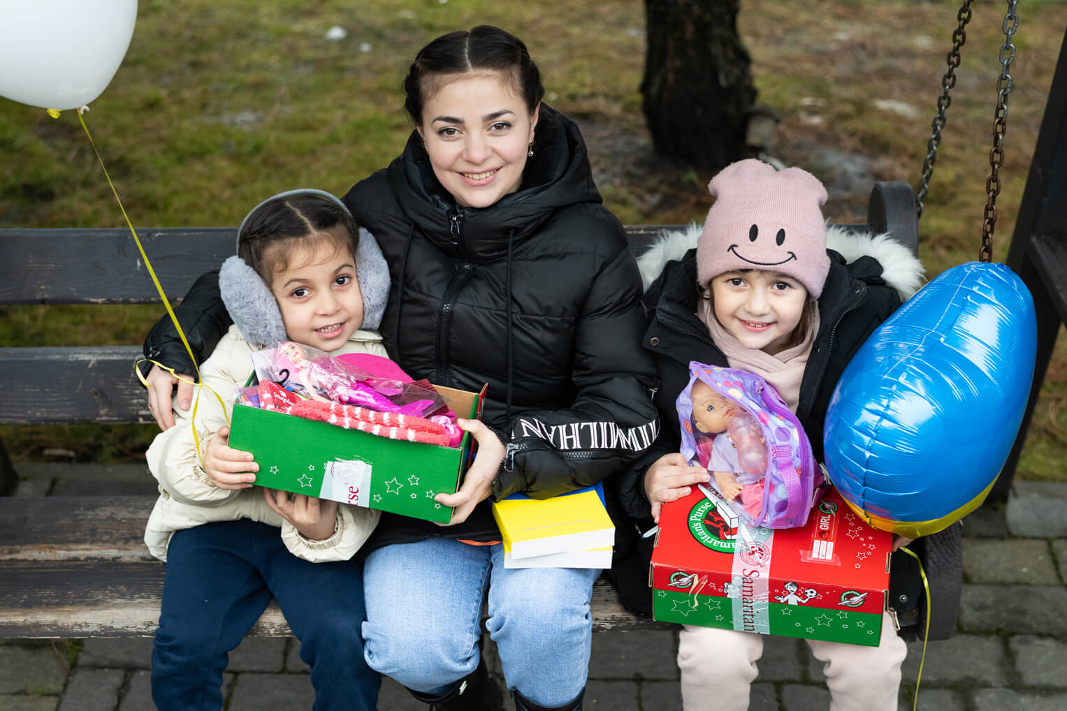 Vira is all smiles with her daughters Anastasia (right) and Ionna after receiving their shoebox gifts. 