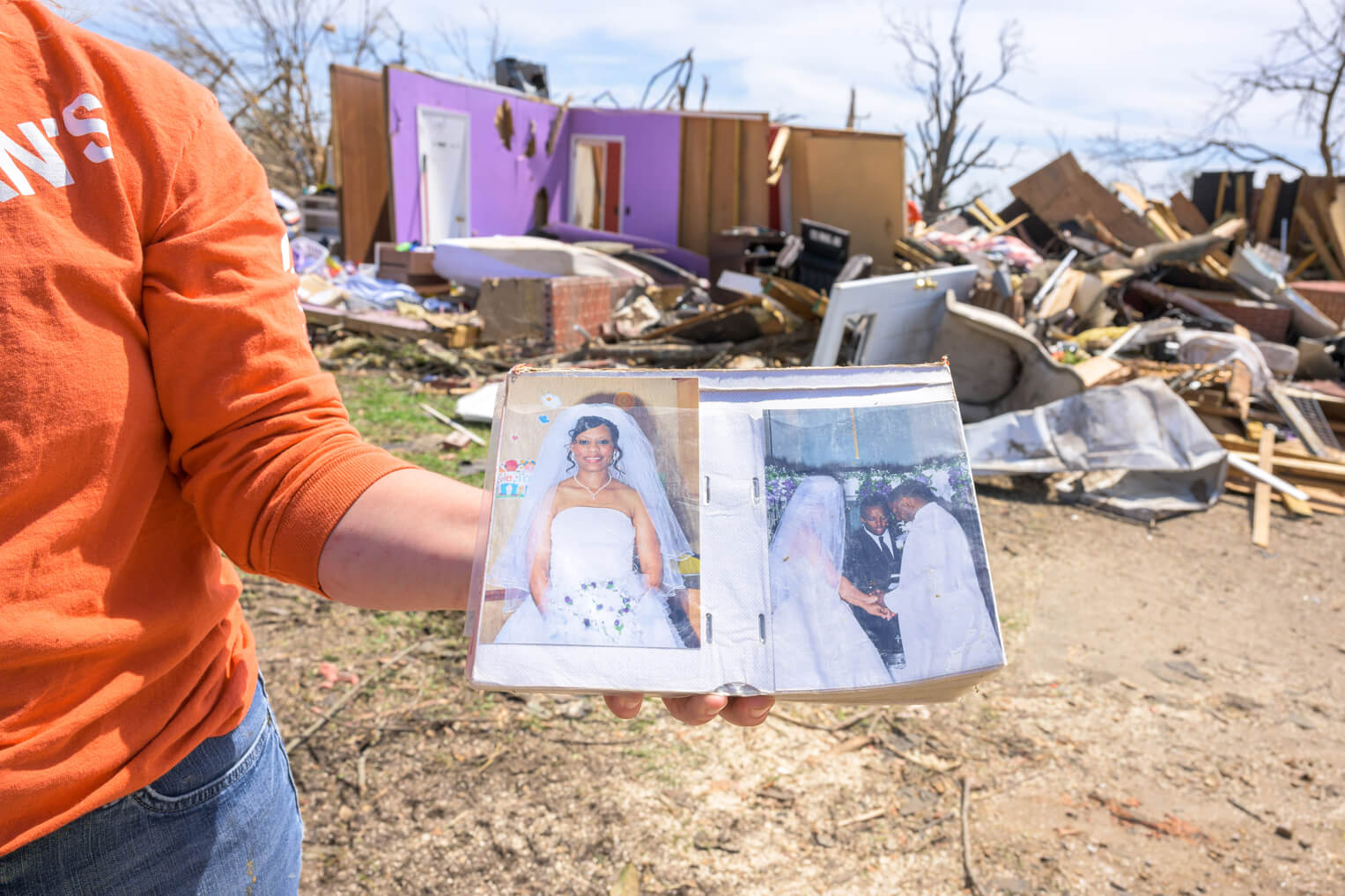 A volunteer displays Becky's wedding album, which was recovered from the wreckage.