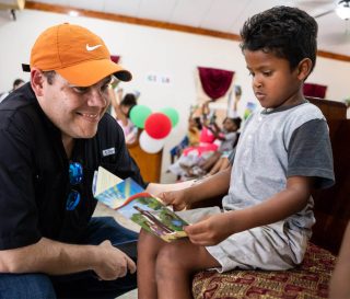 Andy Castillo reads with a young boy at a recent outreach event in Honduras.