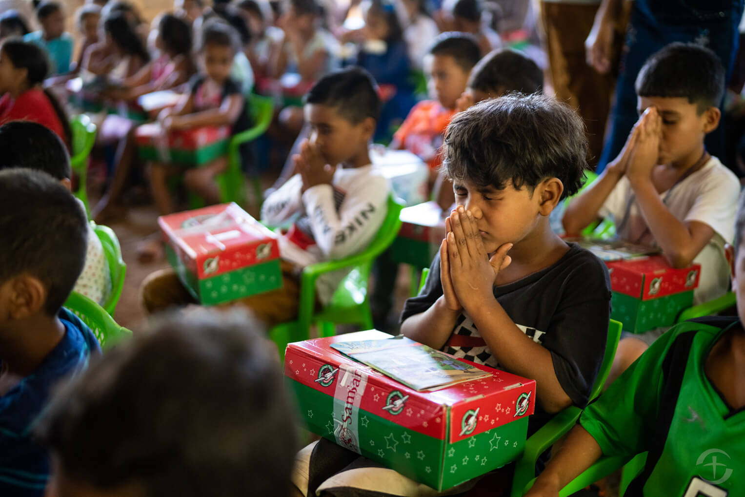 Children pray before opening their Operation Christmas Child shoebox gifts.