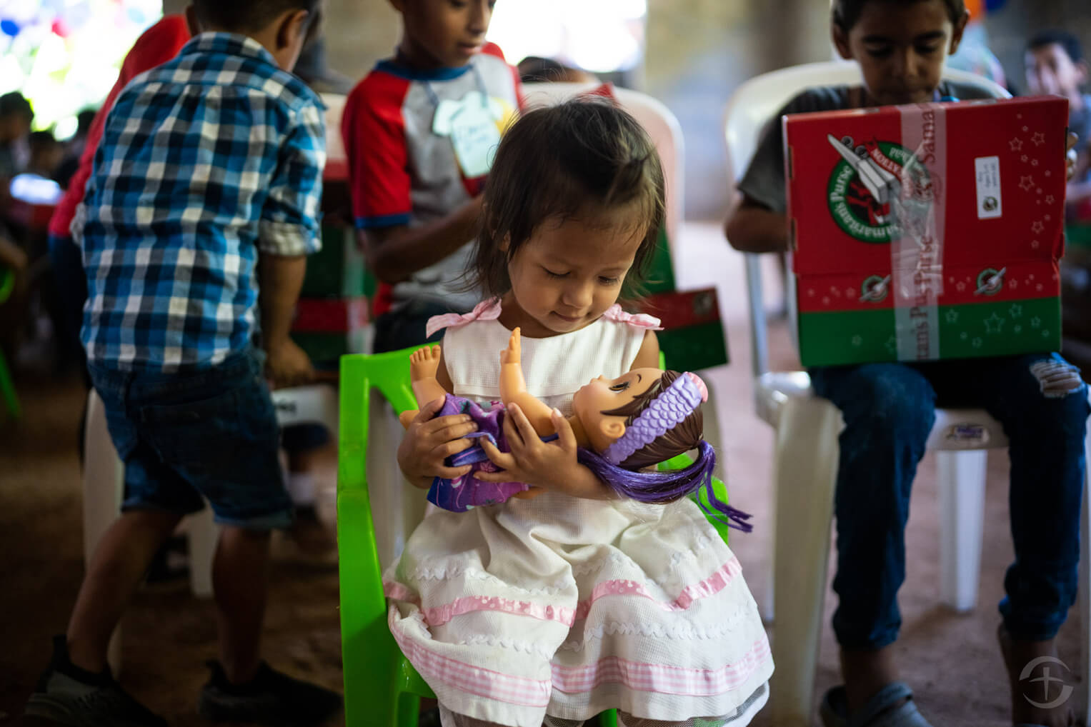 Una niñita disfruta la muñeca que recibió en su caja de regalos.