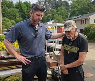 Edward Graham prays with Vietnam combat veteran Dexter Bunte whose Highland Falls home was flood July 9.