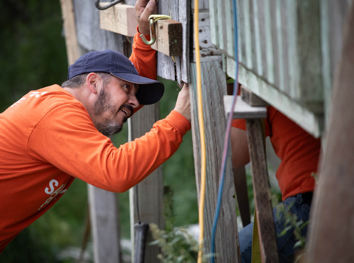 Volunteer Marc Tench worked on repairing the porch of a town leade