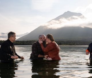 A military couple embraces in the chilly, glacier-fed waters of Lake Clark after their baptism on a bright Friday morning. Retired Army Staff Sergeant Ray Davis and his wife Rebecca attended Operation Heal Our Patriots in Alaska recently.