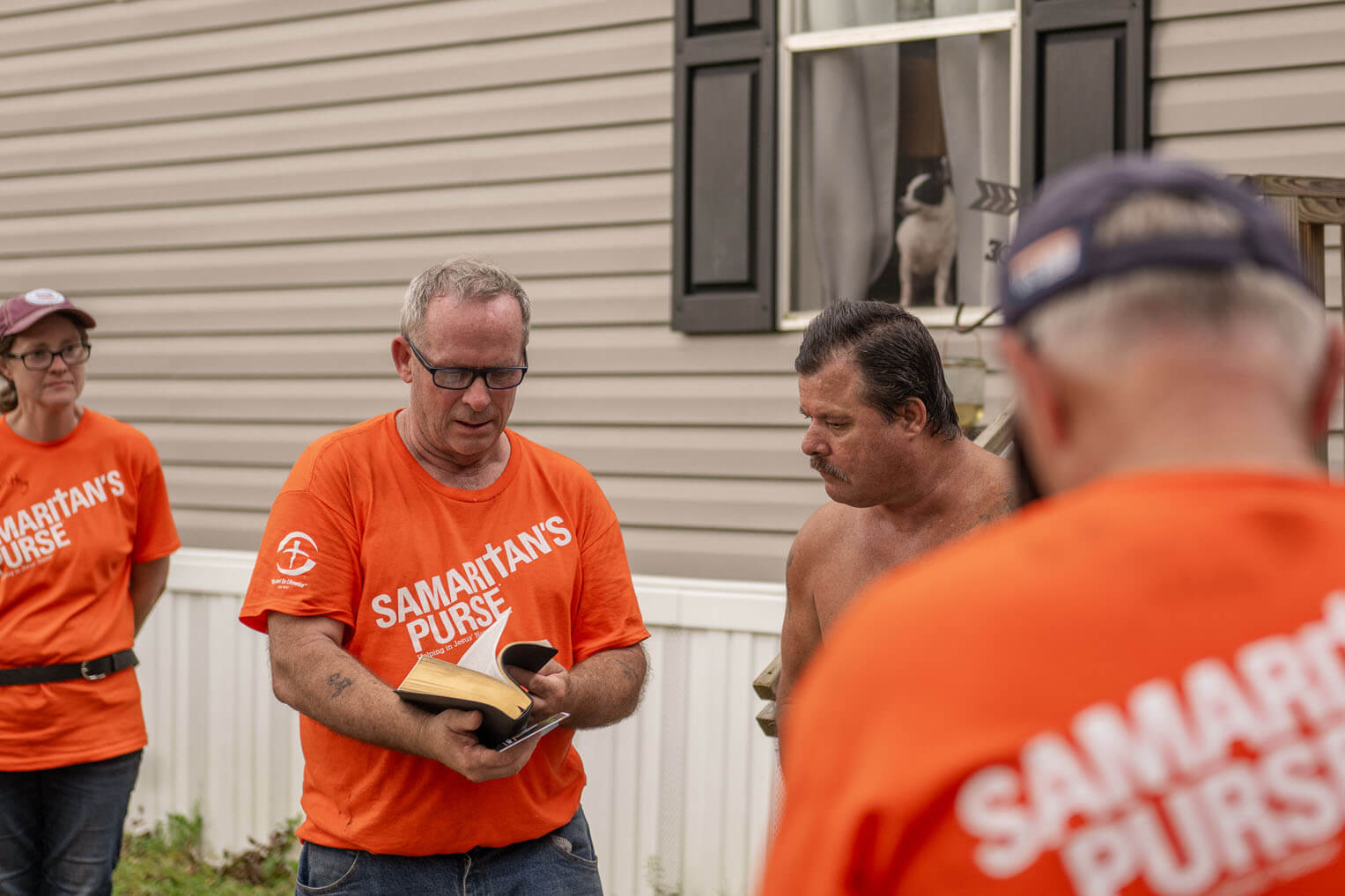 Samaritan's Purse volunteers present a Billy Graham Study Bible, signed by each volunteer, to homeowner Kevin who was trapped for days after the storm.