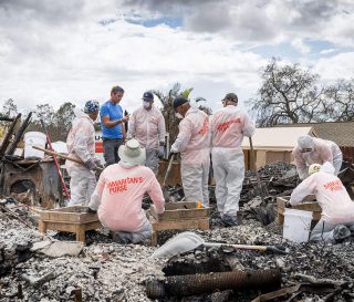 Samaritan's Purse volunteers sift through ashes after a wildfire.