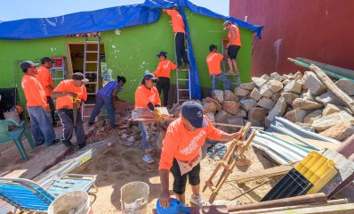 Volunteers from a Mexico City church place tarp of a damaged roof in the hillside neighborhoods of Acapulco.