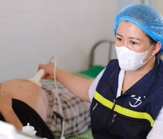 A local partner doctor performs an ultrasound on an expecting mother at a remote clinic in Vietnam's Lai Chau province.