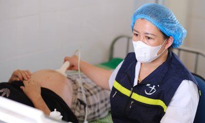 A local partner doctor performs an ultrasound on an expecting mother at a remote clinic in Vietnam's Lai Chau province.