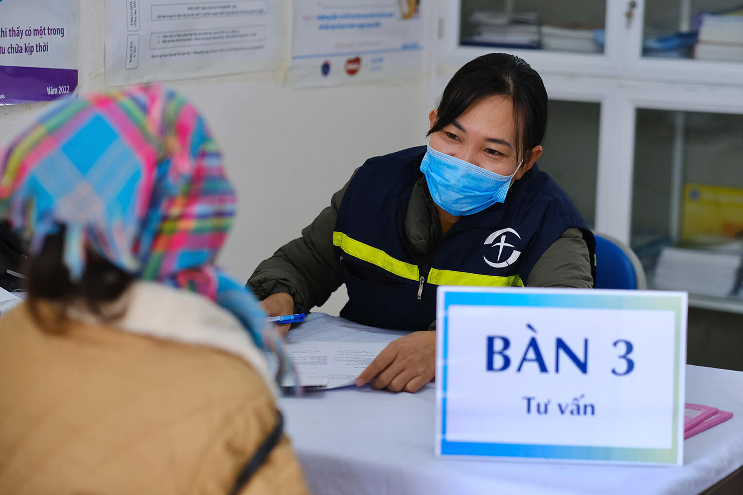 A health care provide signs in an expecting mother for a mobile checkup at a remote clinic in the highlands of Vietnam.