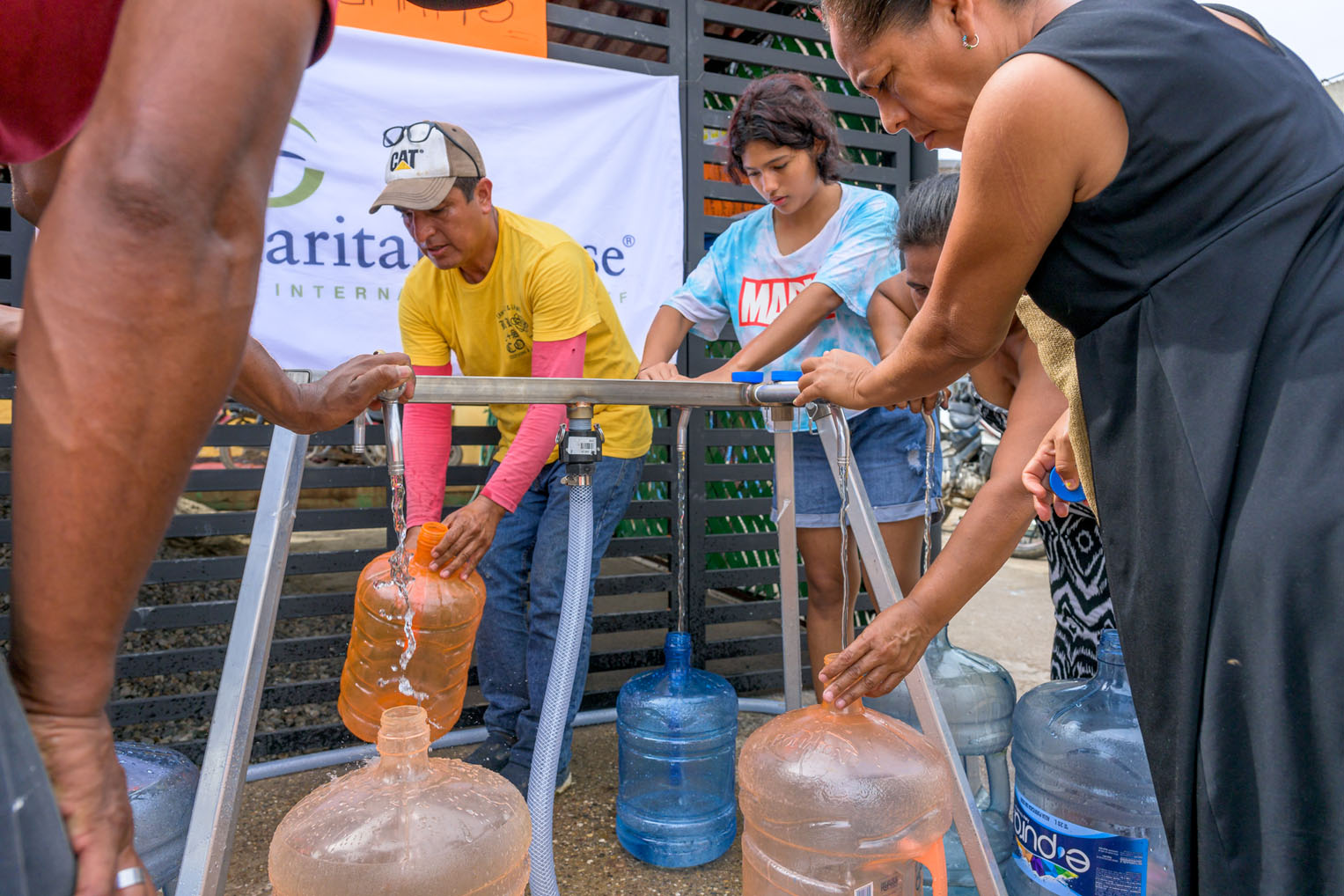 Las familias reúnen agua en la iglesia en Acapulco que se estableció como un punto de recolección de agua.