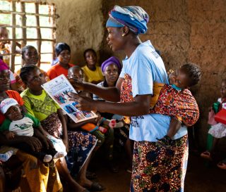 A maternal child health leader mother teaches other parents about proper care during pregnancy.