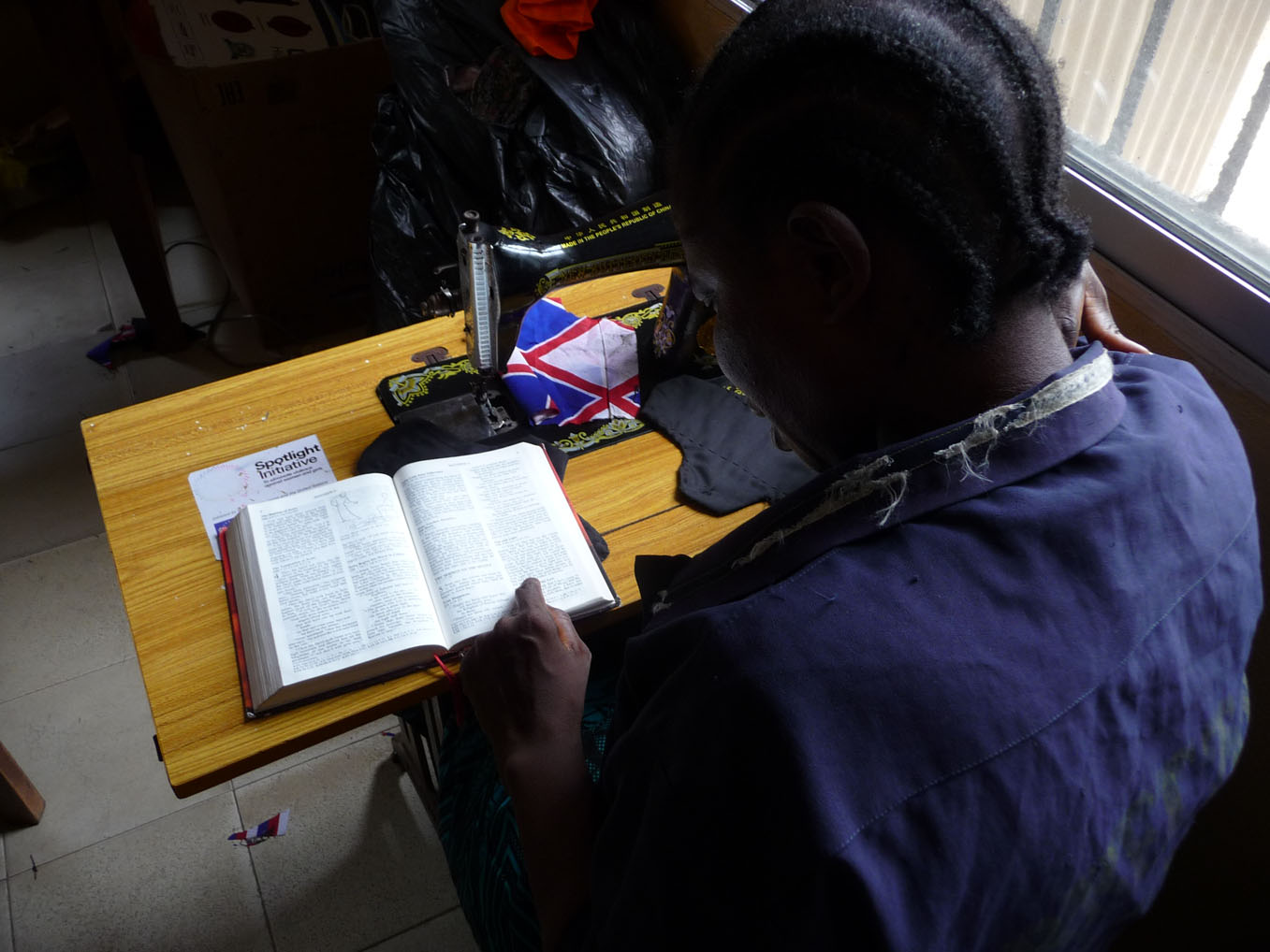 Garmai reads from the Gospels during a break in her sewing class.