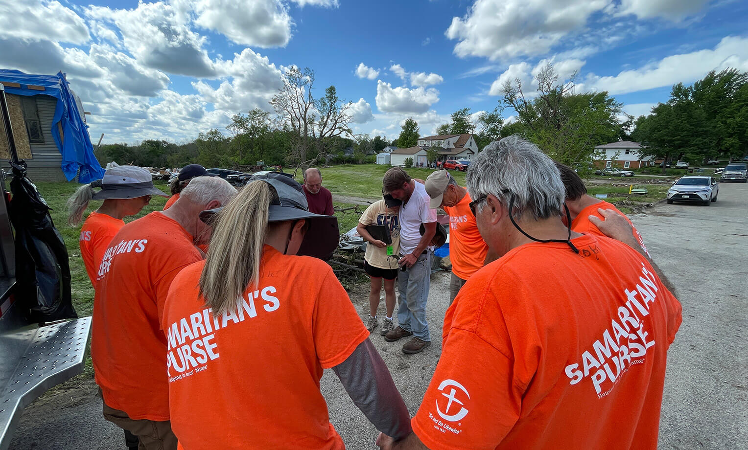 Volunteers pray with Greenfield residents T.J. Oden and Ashley during our work following an EF-4 tornado.