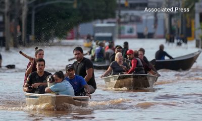 Los habitantes escapan en bote de las comunidades inundadas en el sur de Brasil.