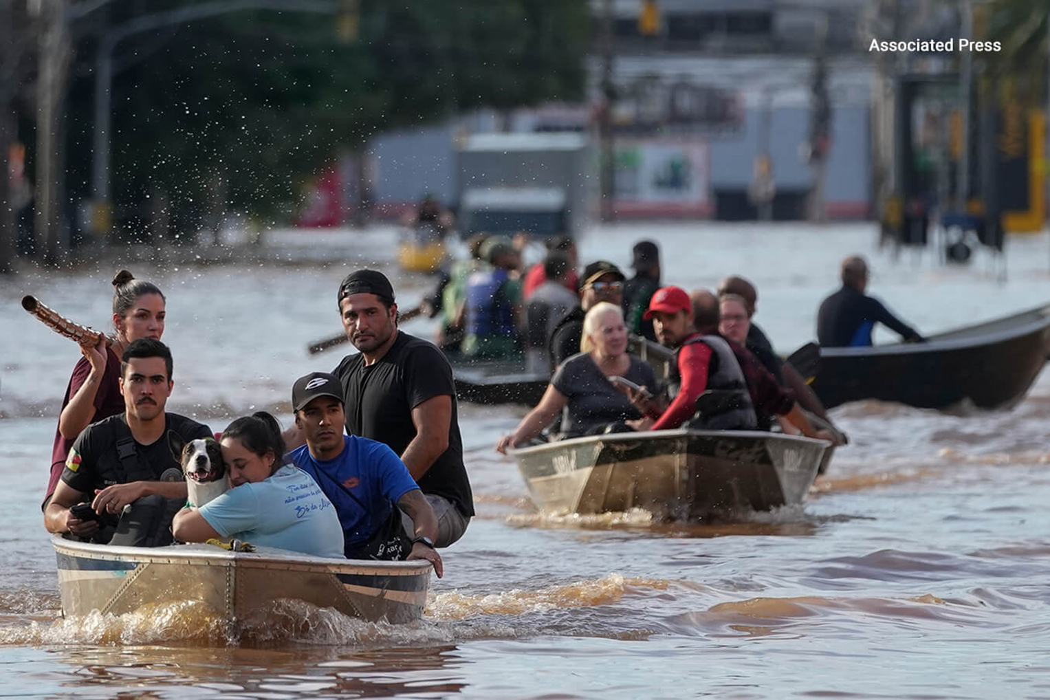 Residents escape by boat from flooded communities in southern Brazil.