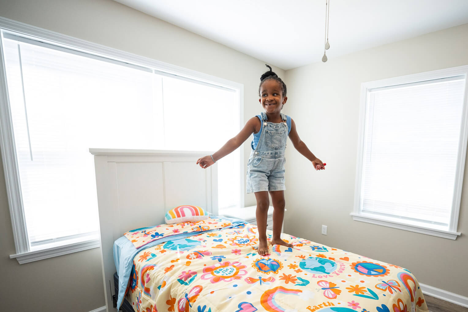Josh and Brenna's daughter jumps joyfully on her bed at the dedication of her family's new home in Mayfield, Kentucky.