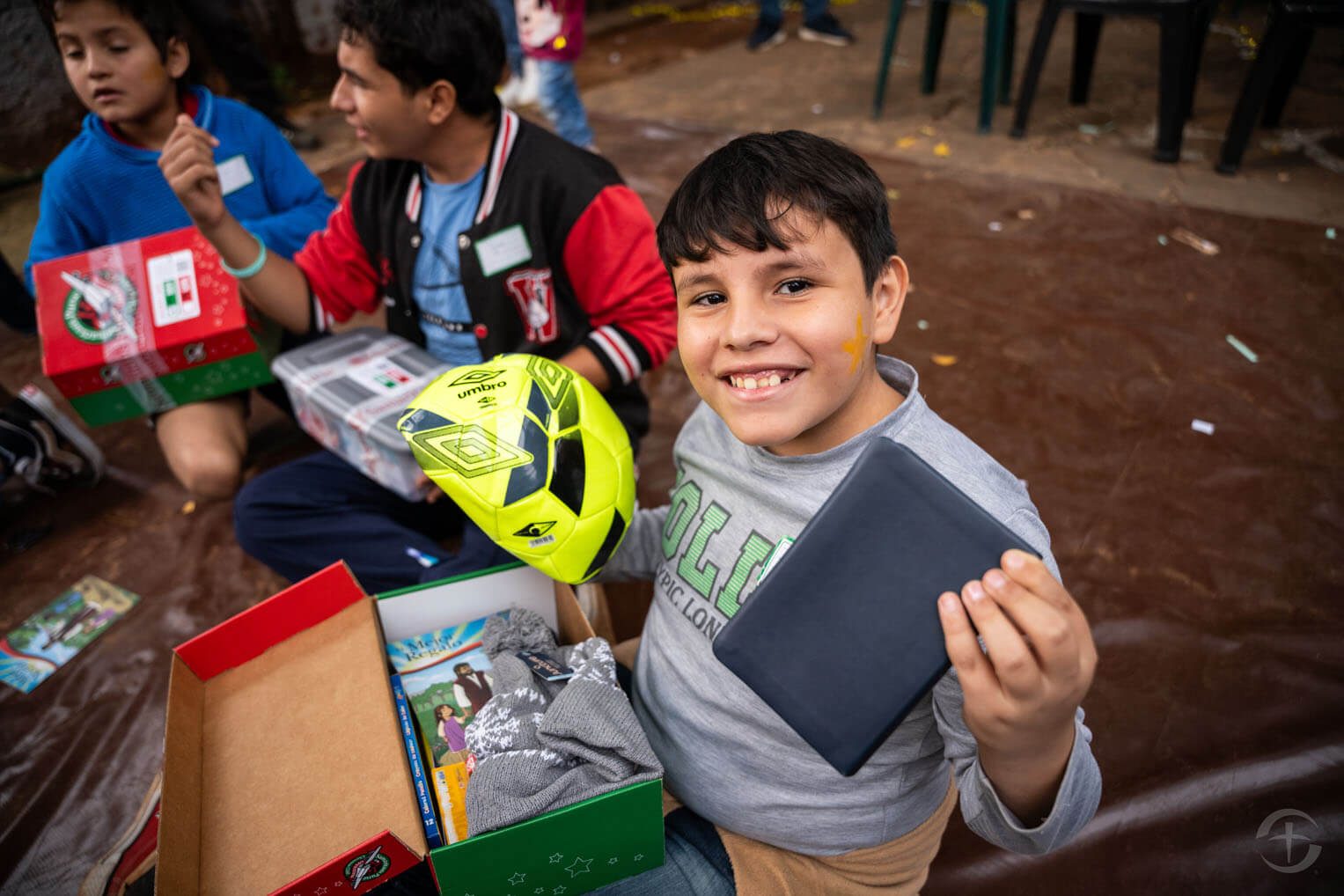 Rafael muestra su nuevo balón de futbol y una Biblia en español.