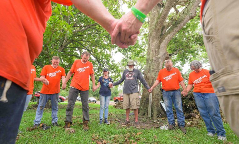 Samaritan's Purse volunteers gather around Tim and Leslie Burch to pray for them and tell them that they are not forgotten by God.