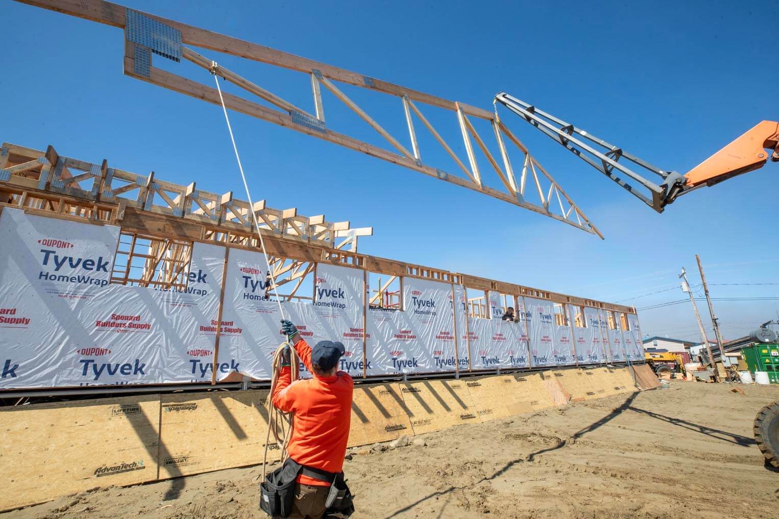 A volunteer helps place a truss on the new church building.