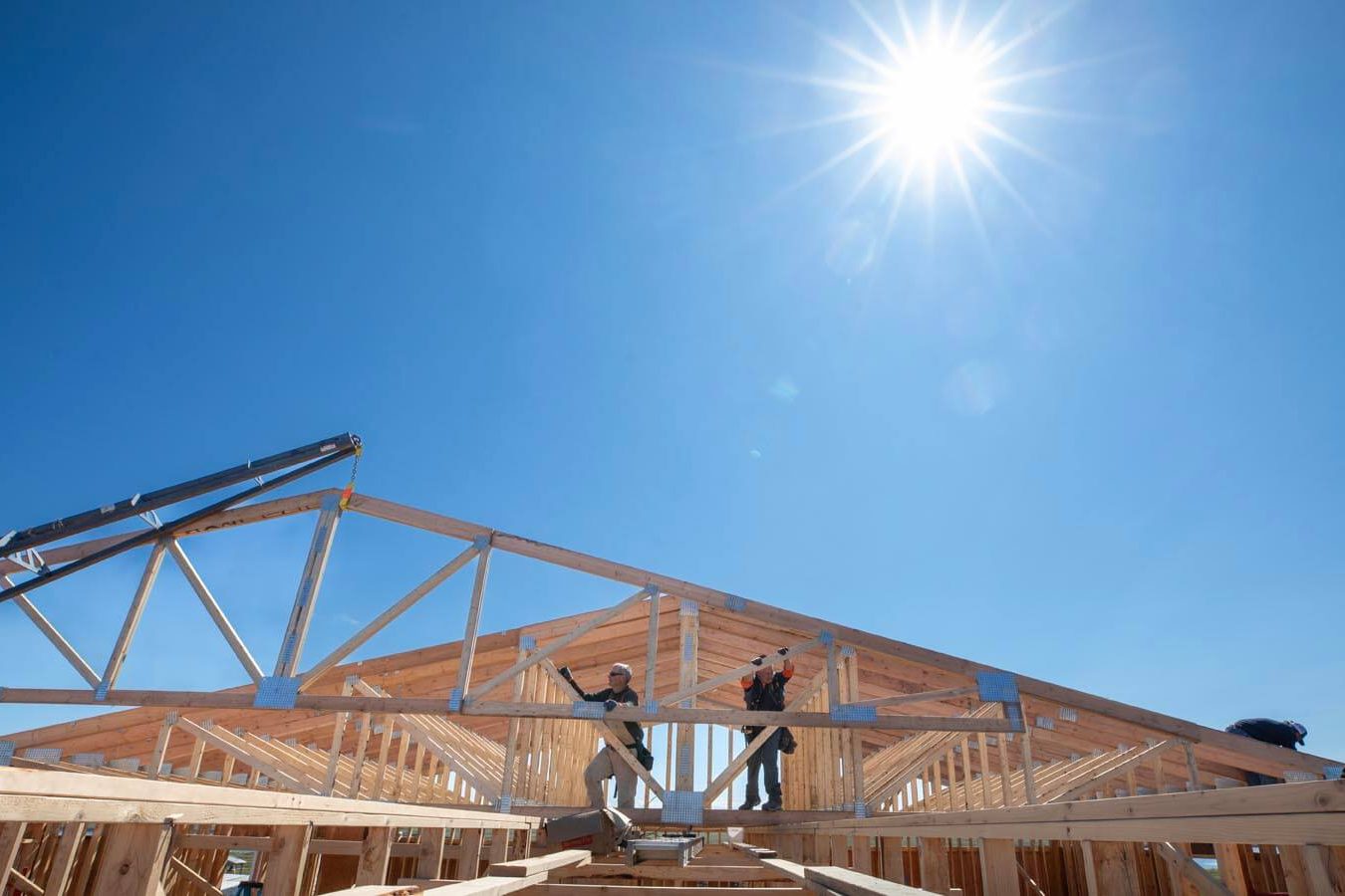 Volunteers work on the church roof under the Alaska sun, a welcome relief after some nasty weather early in construction.