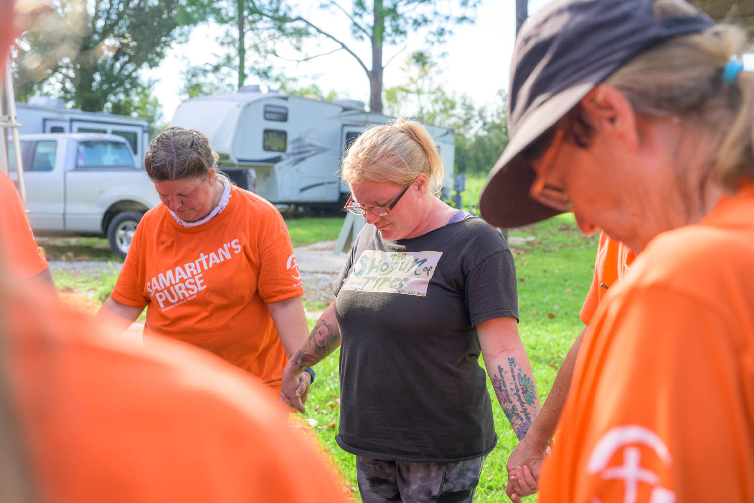 Volunteers pray with Rebecca after work on her home. She recommitted her life to Jesus Christ in discussions with Billy Graham chaplains during our time there.