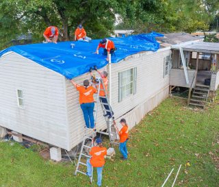 Volunteers help patch Rebecca Clement's roof in Houma, Louisiana, after Hurricane Francine.