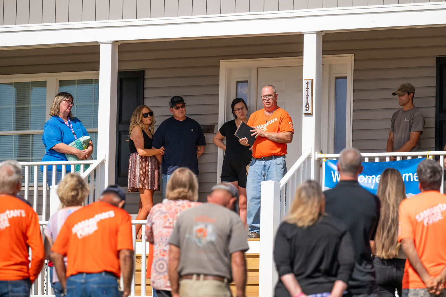 Staff and volunteers gather for prayer after a home dedication.