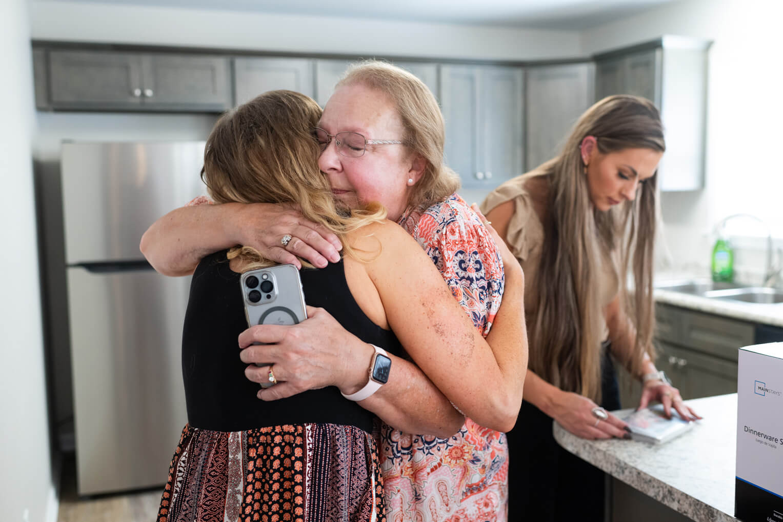 Grateful homeowners embrace after receiving the keys to their new home.