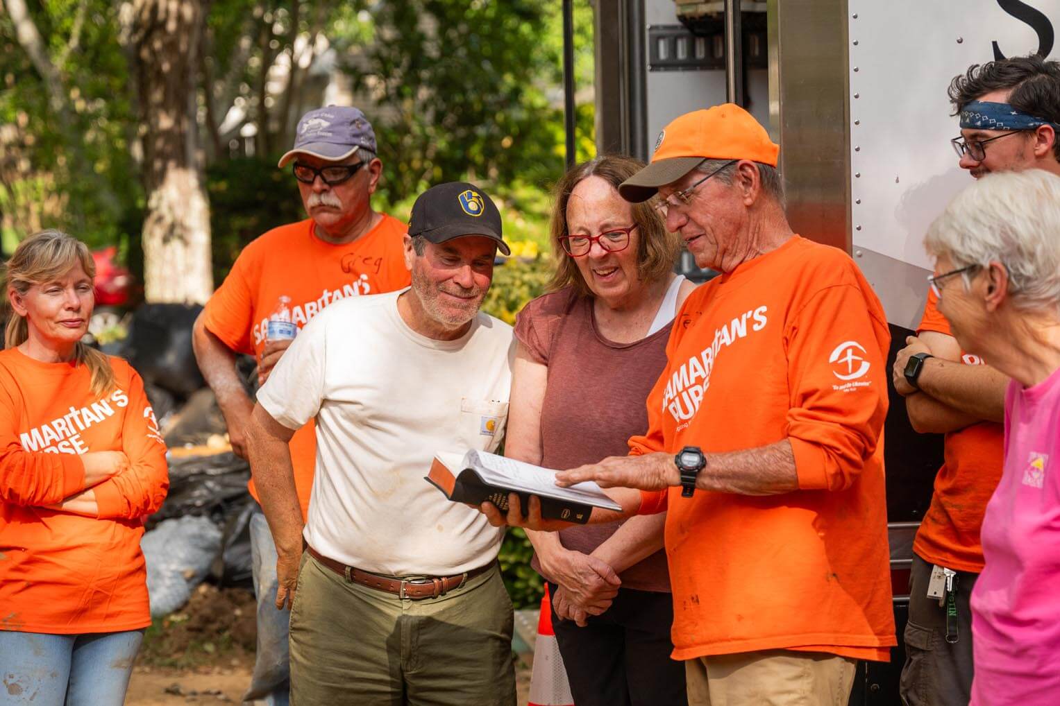 Dennis and Joanne are presented with a Bible signed by volunteers who worked on their property.