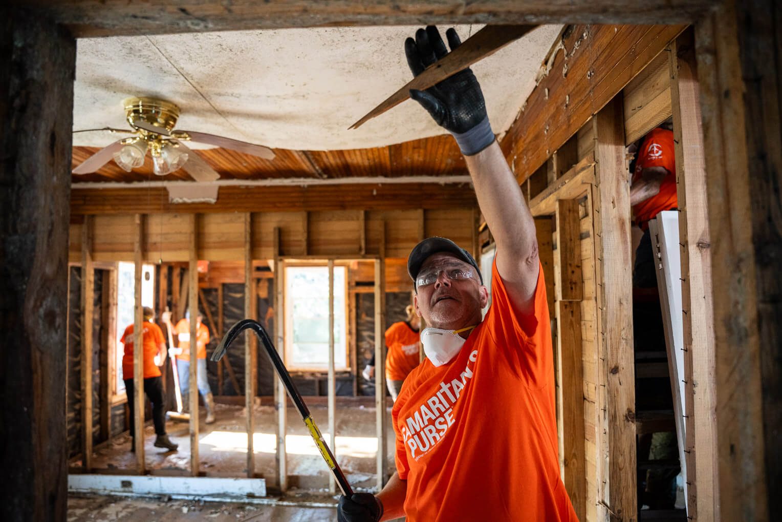 Volunteers gut the Dixon's home, which saw floodwaters rise to the roof.