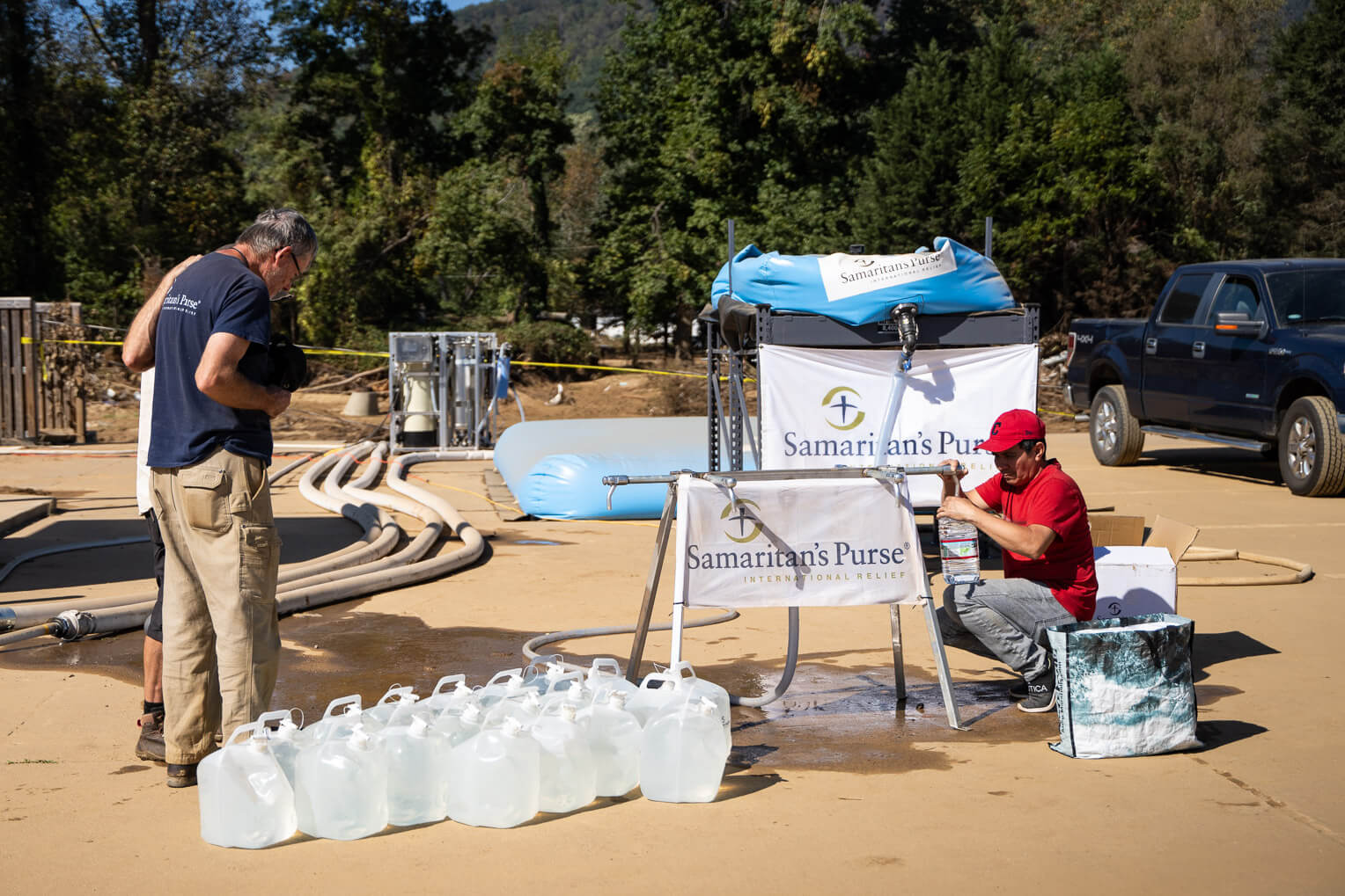 Fowler, left, prays with an individual at the Samaritan's Purse water filtration site in Swannanoa, North Carolina. 