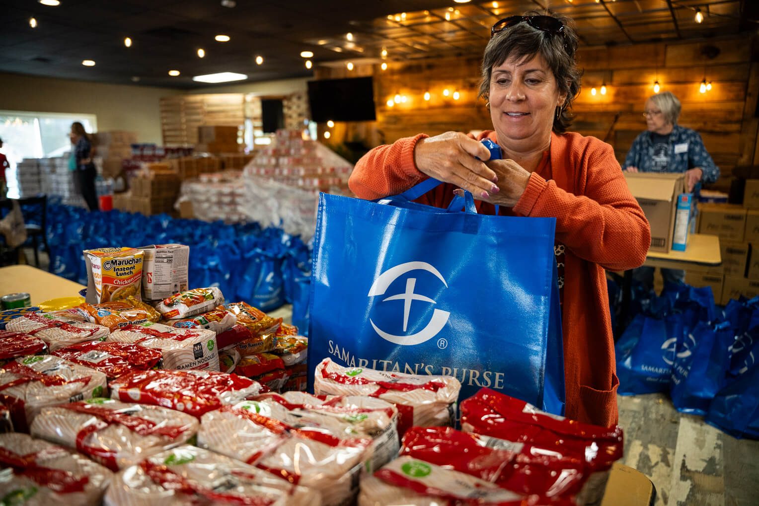 Members of Radiant Church in Arden, North Carolina, pack food and essential supplies such as blankets and solar lights provided by Samaritan's Purse to distribute to residents of Buncombe County and surrounding areas affected by Helene's destruction.