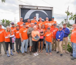 Volunteers gather with homeowners Dale and Tracey Wallace after completing work on their Madeira Beach, Florida home.