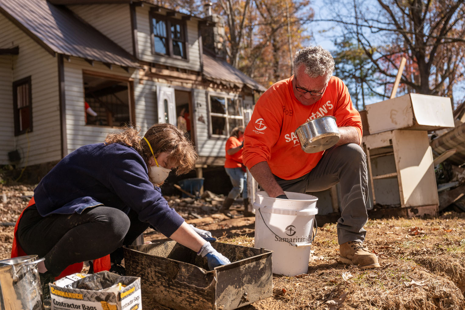 Volunteers search for precious valuables that were salvageable after the floodwaters left layers of mud, some many feet thick, in homes along the South Toe.