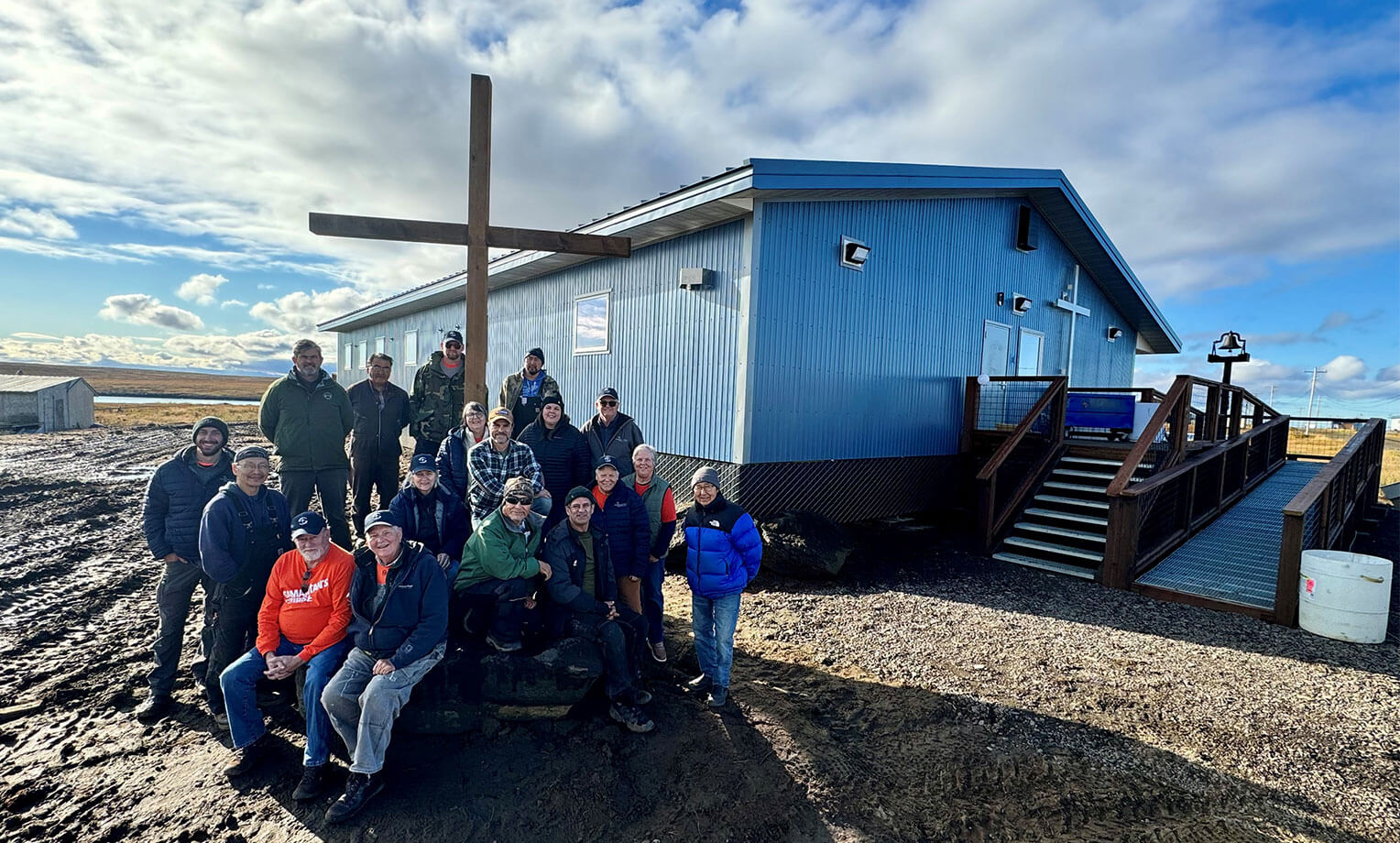 Samaritan's Purse staff, volunteers, and community members with the newly finished church in Mekoryuk.