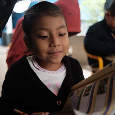 A young girl from the Las Tres Huastecas region in Mexico flips through The Greatest Journey booklet with a smile as she learns more about Jesus.