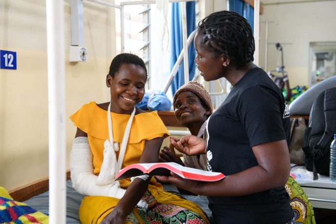 Janet, right, shares truth from Scripture following the surgery on Ireen's elbow. 