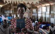 Elizabeth holds the Word of God, which she can now read and teach from after learning to read in the Nuer language in our church-based literacy program.