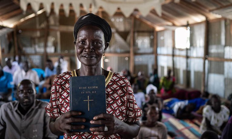 Elizabeth holds the Word of God, which she can now read and teach from after learning to read in the Nuer language in our church-based literacy program.