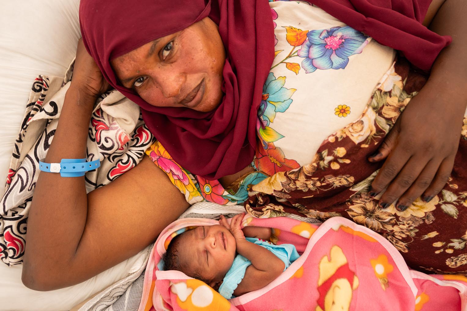 Samar cuddles with her newborn, her third child, grateful for the special care provided by our team.