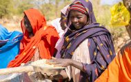 Woman smiles and receives emergency food.