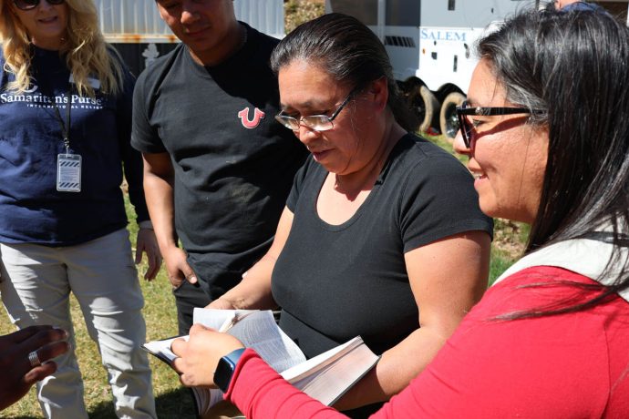 Marlene, a la derecha, le regala una Biblia especial del Billy Graham Training Center a María durante la dedicación de la casa móvil.