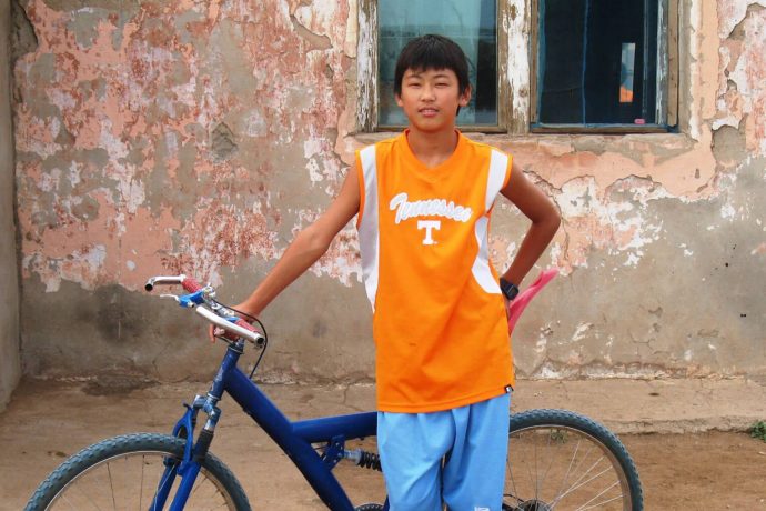 Bat-Ulzii as a teen with a bicycle
